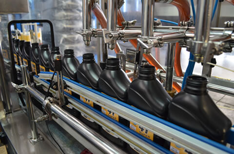 Zoom em linha de montagem de fabricação de lubrificantes.