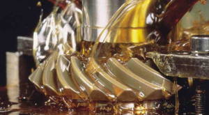 Zoom em engrenagem industrial sendo lubrificada.