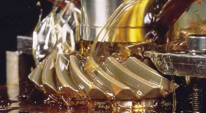 Zoom em engrenagem industrial sendo lubrificada.